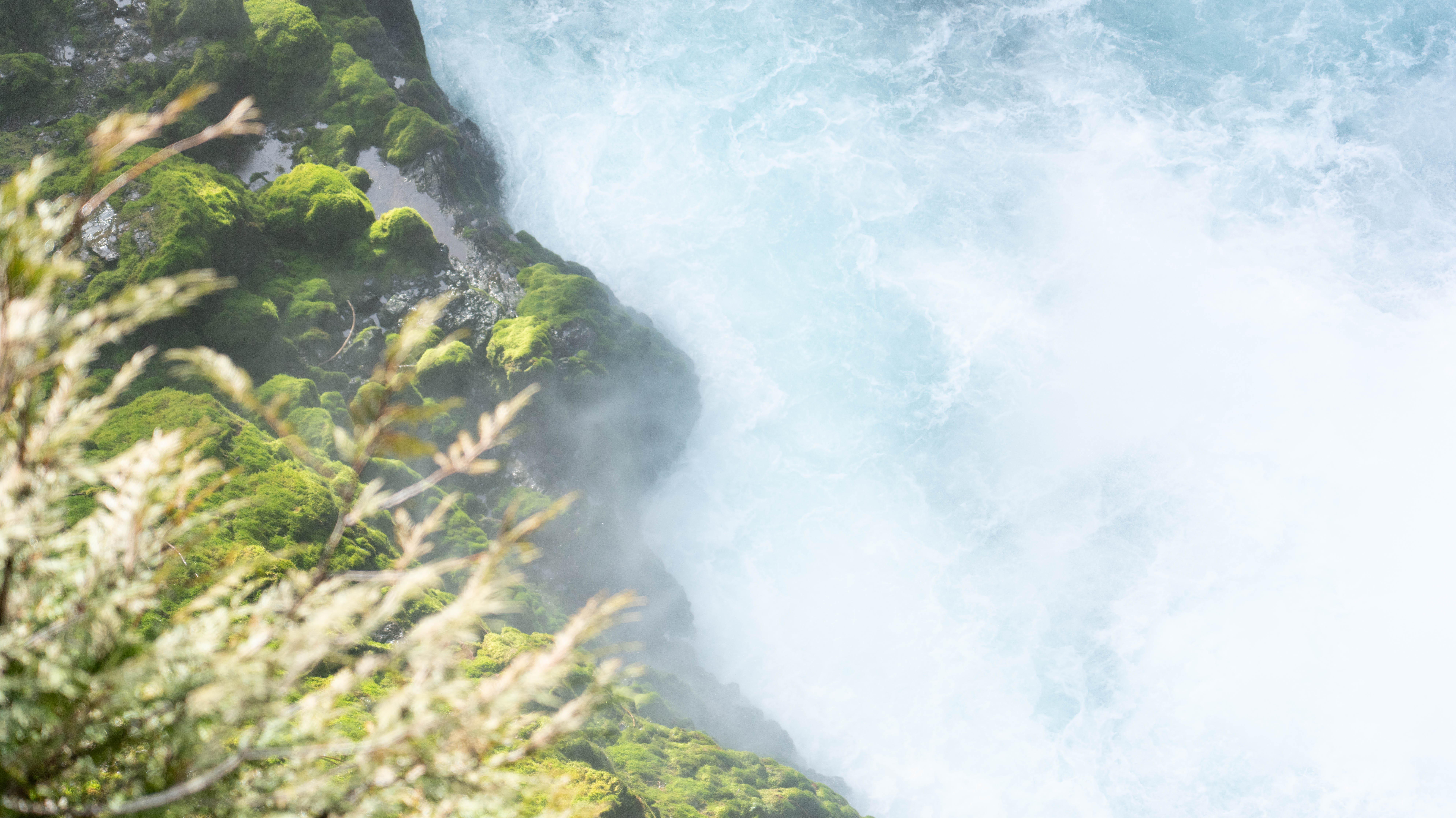 Rushing water cutting through moss-covered rocks.